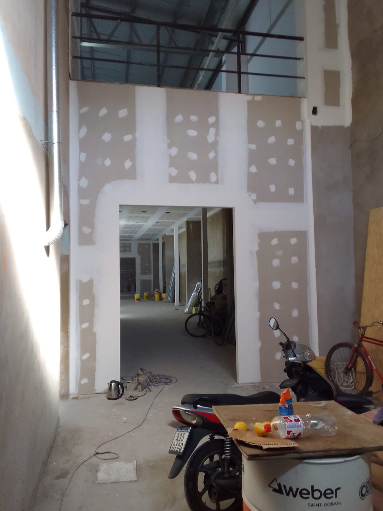 Pasillo de construcción con moto y bicicleta estacionadas — proyecto Deposito en Avellaneda 3, por Arquitecto Guido Niccoli, en B1872 Sarandí